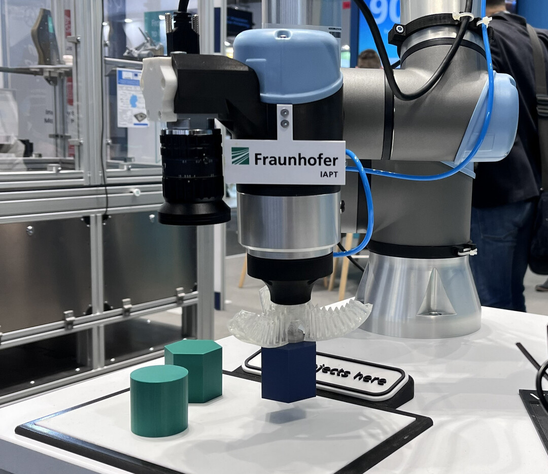 Der kollaborative Roboter mit 3D-gedrucktem Greifer aus Silikon eignet sich ideal für den Umgang mit Obst und kann individuell angepasst werden. Das Bild zeigt eine Vorläufer-Version von der Formnext 2025.