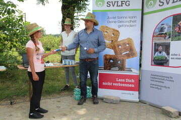 Alexander Apfelbck nutzt den SVLFG-Infostand, um eine seiner Saison-Arbeitskrfte mit einer Tube Sonnencremes auszustatten. 