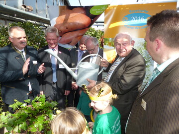Taufe des Gemses des Jahres Batata Bavaria bei Blumen Hhn in Bechhofen (v. l.): BGV-Bezirksvorsitzender Frank Phillips, Leiter der Abteilung Gartenbau am AELF Frth Josef Hofbauer, Kreisrat des Landkreises Ansbach Hans Rummel, Brgermeister Helmut Schnotz, Ministerprsident a. D. Dr. Gnther Beckstein, Betriebsinhaber Peter Hhn mit Bienen des Kindergartens Lummerland
