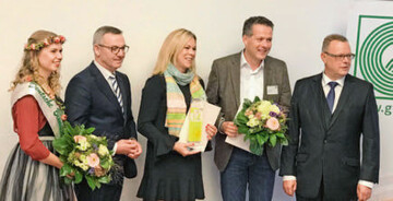 Anne Niemann aus Petershagen erhielt aus den Hnden des Staatssekretrs (rechts) und ZVGPrsident Jrgen Mertz (links, neben der Blumenfee) den Innovationspreis 2018.
