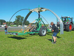 Die Folienhausbögen werden mit zwei Personen vom Heuling-Bügeltransportanhänger in die Bodenanker gesteckt.<br>