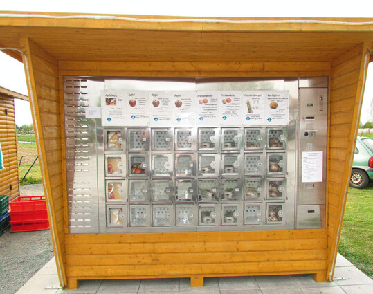 Schmucke Lösung im Spargelhof Rolf Meinhardt: Ein Frischwarenautomat des Modells FWA Cool 25 der Siegfried Roesler GmbH, wurde mit einer Holzkonstruktion umgeben, unter der Verbraucher im Trockenen einkaufen können.